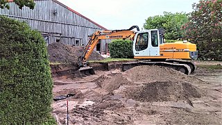 Zisterne eingegraben mit Bagger im Hintergrund 
