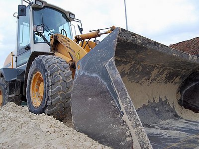 Radlader beim Verladen von Reitplatzsand zum Bau eines Reitplatzes