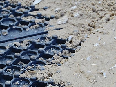 Nahaufnahme von Reitplatzmatten mit aufliegendem Sand-Vlies-Gemisch als Tretschicht