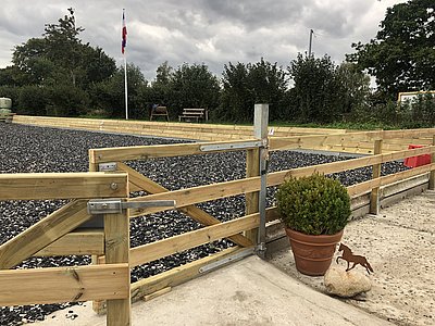 Reitplatz mit Flexground Volltextilboden und Holzumzäunung im Außenbereich